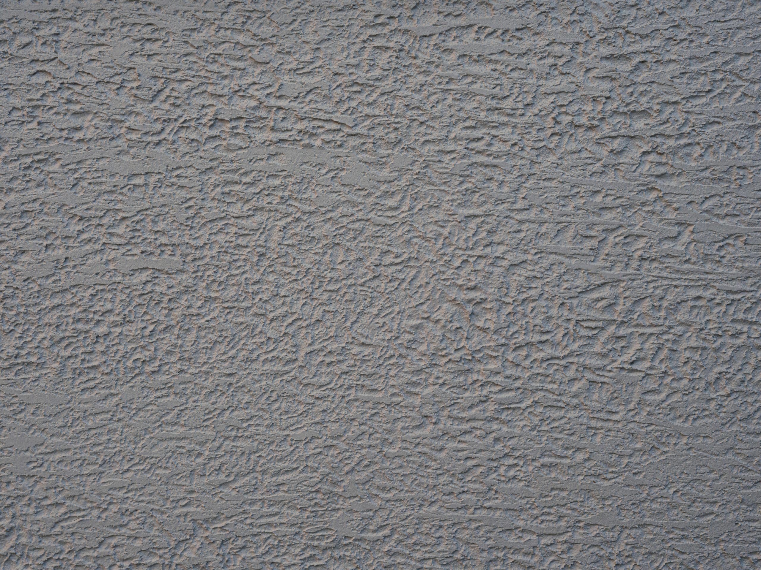 Close-up image of a textured gray wall showcasing rough plaster details.